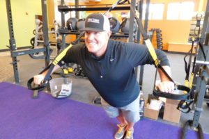 Paul Billings, an owner at the new Anytime Fitness in downtown Washougal, demonstrates the use of a suspension trainer. Billings says his goals for the new business are to be the "premier gym in Washougal and to create a surprisingly personable customer experience."