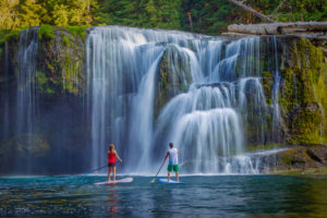 Two paddleboarders share the adventure of a lifetime under a waterfall in the Columbia River Gorge. (Photo courtesy of Richard Hallman)