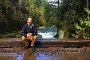 Steven Epling takes a moment to relax in front of Reeder Falls, part of his recently acquired property in Skamania County. He purchased 131 acres, including Naked Falls, for $275,000, from Weyerhaeuser Company. (Photo contributed by Steven Epling)