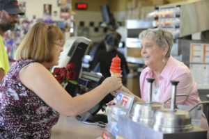 Wilma "Willi" McOmie (right) serves a cherry-dipped ice cream cone to a customer on Sept. 1, at the Camas Dairy Queen. McOmie, 80, has owned the restaurant for 37 years, and plans to retire by the end of this year. 