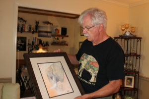 Vancouver novelist and artist Gary Watson at his home studio in late September, prepares for his upcoming art show at the Second Story Gallery, above the Camas Library at 625 N.E. Fourth Ave. The show runs Oct. 6-28. Here, Watson shows his painting of "Mara," an African elephant featured in his last novel, Mercy in Masquerade. (Kelly Moyer/Post-Record)