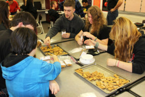 Camas High seniors Ben Cooke, 18, (upper right) and Keelie LeBlanc (upper left) work with Transition House students (clockwise from center right) Maddi Kohler, 18; C.C. Bewick, 19; Lindsey Meritt, 18; and Gavin Johnson, 19, to package "Puppermakers" dog treats on Friday, Nov. 17. 