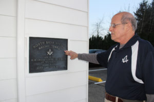 Worshipful Master Art Liss, head of the North Bank No. 182 Masonic Lodge in Washougal, points to the cornerstone of the historic lodge, located at 888 Washougal River Road, Washougal.