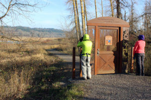 Chris Marlahan (left) and Michelle Marlahan (right), of Washougal, look through binoculars to see wintering waterfowl inside the Steigerwald Lake National Wildlife Refuge on Wednesday, Dec. 13. The gate near the couple leads to a spur trail, which is closed from Oct. 1 to May 1 to help protect the wintering wildlife from human interaction. 