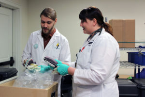 Phlebotomists Jake Cole (left) and Leah Hauge (right) with Bloodworks Northwest, handle donated blood on Monday, Dec. 18, at the Camas Public Library. The two Bloodworks Northwest employees said donors are needed this week and throughout the holidays to help replenish blood supplies after a fatal train crash north of Olympia killed three people and sent more than 70 passengers to regional hospitals.