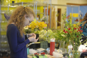 Kate Northcut, an employee of Flowers Washougal on "E" Street, creates corsages for the April 28 Washougal High School prom. "E" Street, from Sixth to 24th streets, is one of several potential "opportunity zones" in Washougal, that could be part of a tax incentive program to stimulate investment. 