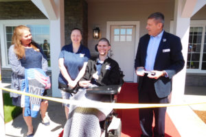 Bill Ivey, executive director of Homes For Our Troops (HFOT), presents a large ceremonial key to Alex and Kim Hussey, as HFOT Community Outreach Coordinator Mary Espinoza looks on, Saturday, May 12, outside the Husseys' new home in the Washougal area. Alex, an Army Specialist, lost both of his legs and left hand, and he sustained a traumatic brain injury when an improvised explosive device was set off near him in Afghanistan in 2012. 