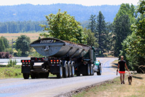 Rachel Grice and her dog, Rusty, take a walk near Grice's Washougal home off Southeast 356th Avenue in the Columbia River Gorge National Scenic Area. Trucks (like the one pictured above) hauling material from a nearby rock quarry are a constant presence next to Grice's house. She says the trucks' noise, dust and safety hazards are a major concern for her family, which includes her four homeschooled children, ages 8 to 12. 