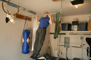 Daily workouts at home are no problem for Nathan Loren, who performs pullups inside the garage of his Camas house.