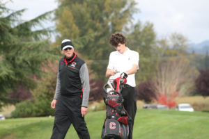 Camas head golf coach Ed Givens (left) encourages Bryan Hansel (right) during the district tournament at Tri-Mountain Golf Course in Ridgefield, Oct. 9. 