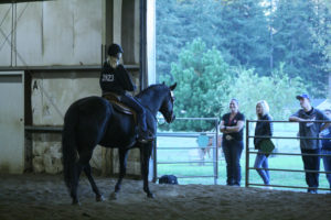 Coach Nikki Harrington (second from left) encourages a member of the Camas equestrian team at Green Mountain Stables in Camas. 