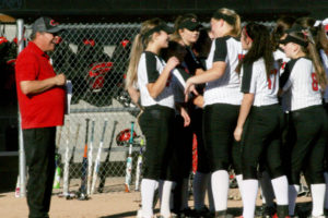 The Camas Papermakers celebrate their first slowpitch softball district championship win with assistant coach Don Wolf (left). 