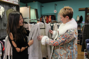 Allure Boutique owner Bobbi Lee (left) shows customer Joy Soyster, of Portland, a new cardigan at her downtown Camas shop on Nov. 15. This will be Lee's third year celebrating "Black Friday" with specials and discounts for downtown Camas' "Little Box Friday" on Nov. 23, and "Shop Small Saturday" on Nov. 24. 