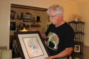 Local artist and wildlife activist Gary Watson holds one of his elephant paintings at his Vancouver home. Watson will be the featured artist throughout February at the Camas Gallery in downtown Camas. (Post-Record file photo)