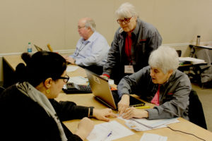 Local AARP Foundation Tax-Aide coordinator Sherry Davis (right) inspects documents provided by taxpayer Nadia Samiee (left) of Vancouver at the Camas Public Library on Feb. 14, while Tax-Aide counselor Vicki Millard (second from right), of Washougal, watches and Tax-Aide counselor Mike Leonardich (third from right), of Vancouver, works on another tax return. 