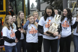 The Washougal girls basketball team shows off their state basketball championship trophy, now engraved with Washougal High's name.