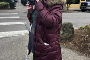 Tori Eastman, 12, a sixth-grader at the Washington State School for the Blind, holds her camera close to her eyes to see the photos she captured during a school field trip to downtown Camas on March 11. 