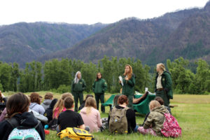 Washougal sixth graders from Canyon Creek Middle School listen to four U.S. Forest Service rangers talk about the Columbia River Gorge's post-fire recovery, at their Explore the Gorge outdoor school, hosted by Friends of the Columbia Gorge, and funded in part by a $5,000 Camas-Washougal Community Chest grant, in June 2018. Forest Service rangers, pictured from left to right, are Angel Robinson, Sophie Steckler, Elisabeth Dare and Kat Schut. In the background, a view of the Oregon side of the gorge damaged by the September 2017 Eagle Creek Fire.