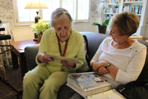 Cay Knapp Smith (left) and her niece-in-law, Rosemary Knapp, look through family photo albums inside a sitting room at Cascade Inn, the Vancouver senior living facility where Knapp Smith lives. Knapp Smith, who turned 100 on Aug. 27, has family roots in the Camas area that date back to the days before Washington was considered a state. (Photos by Kelly Moyer/Post-Record)