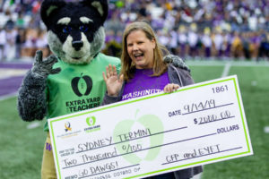 Columbia Gorge Elementary School teacher Sydney Termini holds a check for $2,000, which she received Sept. 14 at Husky Stadium in Seattle. Termini was one of five Washington teachers selected for recognition by the Extra Yard for Teachers program. (Contributed photo courtesy of University of Washington)