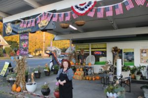 Mystic Gardens owner Leslie Rick stands outside the Camas floral and gift store, which is decorated with American flags for Veterans Day, on Monday, Nov. 4. Rick is holding wedding and vow-renewal ceremonies for military veterans on Sunday, Nov. 10. (Doug Flanagan/Post-Record)