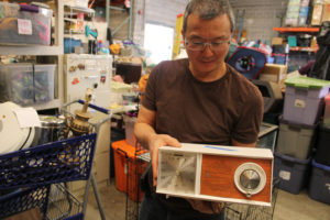 Pat Kagi inspects a vintage radio in need of repair at the ReTails Thrift Store in Vancouver on Friday, Nov. 8. (Kelly Moyer/Post-Record)
