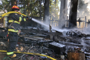 Contributed photo courtesy of Camas-Washougal Fire Department 
 A Camas-Washougal Fire Department firefighter extinguishes an outbuilding fire in Washougal in September 2018.