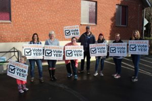 Members of the Washougal Citizens for Schools Group hold signs urging Washougal School District voters to "vote yes" on the district's replacement levies on the Feb. 11 special election ballot. Pictured from left to right: Ellie Furze-Brown, Renae Burson, Linda Henderson, Erin Eaton, Nathan Knottingham, Angelah Quidachay-Ham, Cindy Coons and Erin Darling. (Contributed photo courtesy of Nathan Knottingham)