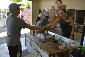 Washougal artist Angela Ridgway greets a customer at the 2019 Washougal Studio Artists tour. Ridgway, the event's creator and organizer, led an effort to move the 2020 tour to a virtual format. (Contributed photo courtesy of Angela Ridgway)