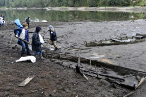 Contributed photo by Greg Wahl-Stephens for the Columbian 
 Volunteers, including members of scout troop 424 check out the skeletons of wooden boats as they clean up the shoreline and surrounds of Lacamas Lake, with the water level lowered, in Camus, Sept 30, 2017. (Post-Record file photo)