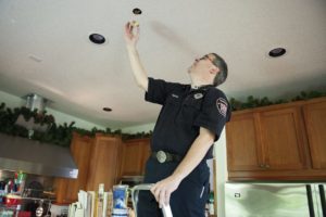 Camas-Washougal Fire Department Deputy Fire Marshal Randy Miller exposes a home sprinkler unit in the kitchen of his house in April 2016. (Contributed photo courtesy of Amanda Cowan/The Columbian)