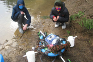 Camas middle-schoolers Rafa Lavagnino, 13, (left) and Tenzin Kelsang, 13, test their mobile, algae-filtering "algaegator" invention at Camas' Lacamas Lake in the spring of 2021. The seventh-graders' work recently earned them a spot in a national STEM competition sponsored by the United States Army and the National Science Teaching Association, as well as a $5,000 grant to improve the toxic-algae filtration device. (Contributed photo courtesy of Ayn Lavagnino)