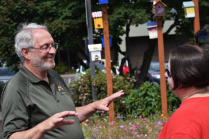 Washougal City Council member Paul Greenlee (left) chats with Jemtegaard Middle School art teacher Dani Allen during a reception for Washougal middle school students, who created designs on birdhouses hung outside Washougal City Hall, on June 23, 2018. (Post-Record file photo)