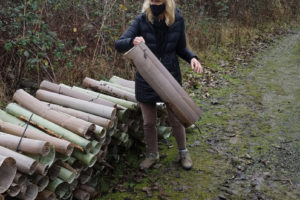 Washougal resident Barbara Gagnier stacks plastic tubes on the Washougal River Greenway trail. Gagnier and Washougal resident James Mahar removed about 3,000 of the tubes from trees along the trail in December 2020 and January 2021. ((Contributed photo courtesy Barbara Gagnier)