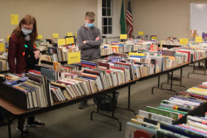 People browse used books inside the Camas library's second-floor meeting rooms during the Friends and Foundation of the Camas Library's annual December book sale on Friday, Dec. 3, 2021. (Kelly Moyer/Post-Record)