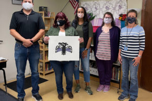 Cowlitz Indian Tribe artist Sarah Folden (second from left) presents the logo she designed for the Washougal Learning Academy to the school's principal, Jason Foster (left). (Contributed photo courtesy of Jason Foster)