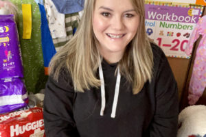 Washougal resident Jeannine Mills sits near some of the items she has collected for foster children in need. Community members can donate needed supplies for foster children through donation bins located throughout the city of Washougal. (Contributed photo courtesy of Jeannine Mills)