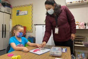 Washougal School District dual language program teacher Veronica Paredes (right) assists Hathaway Elementary School student Oakley Brush with an assignment in October 2021. Paredes, a former paraducator, earned a teaching certificate through the Educational Service District 112's ESD-U program. (Contributed photo courtesy of the Washougal School District)