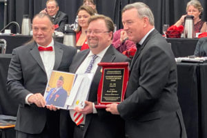 Jemtegaard Middle School history teacher Scott Rainey (center) receives the 2021-22  Veterans of Foreign Wars Department of Washington's Citizenship Education Middle School Teacher of the Year award during a banquet in Yakima, Wash., on Saturday, Jan. 15, 2022. (Contributed photo courtesy Washougal Schoool District)