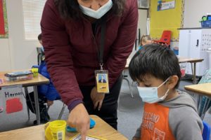 Washougal School District dual language teacher Veronica Paredes (left) helps kindergarten student Javier Pena Contreras with an assignment in 2022. (photo courtesy of the Washougal School District)