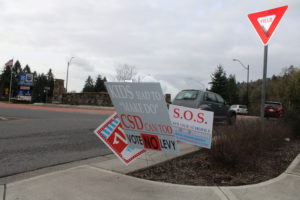 Traffic flows past election signs placed near the northeast entrance of Camas' Northwest Sixth Avenue traffic roundabout on Monday, Feb. 8, 2021. (Kelly Moyer/Post-Record files)