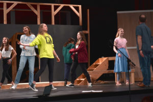 Liberty Middle School students (from left to right) Payton Steiger, Anna DeGroot, Lena Ruddy, Sofia Muravez, Bailey McGlothin and Cadence Lee take direction from director Erik Edmundson (far right) during a rehearsal for "Oliver! JR" at the Joyce Garver Theater on Monday, April 25, 2022. (Contributed photo by Susan Maszak)