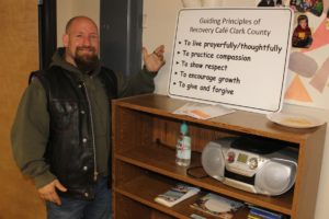 Recovery Cafe Clark County recovery coach Abe Lepak shows off a sign that contains the nonprofit organization's guiding principles at the Children's Home Society of Washington building in Washougal on Monday, April 30, 2022. (Photos by Doug Flanagan/Post-Record)