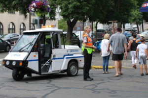 Camas parking enforcement officer Debrah Riedl helps guide traffic near the end of the Camas Days Kids Parade on Northeast Fourth Avenue in downtown Camas on Friday, July 22, 2022. (Kelly Moyer/Post-Record)