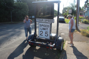 Washougal residents Angi Waring (left) and Jennifer Birkenfeld examine a mobile speed display trailer near their homes on Thursday, Aug. 11, 2022. Waring is leading an effort to convince the city of Washougal to install speed bumps and reduce the speed limit on "G" Street, citing safety concerns. (Photos by Doug Flanagan/Post-Record)