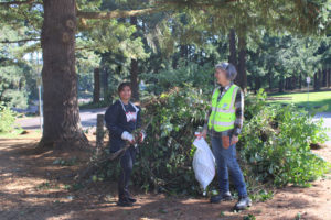 Kelly Moyer/Post-Record 
 Port of Camas-Washougal Commissioner Cassi Marshall (right) and ivy pull volunteer Sydney Tran, 16, a junior at Union High School in Vancouver, show one of several piles of ivy pulled from trees near Lacamas Lake during an annual lake cleanup and ivy pull event held Saturday, Sept. 30, 2023, at Heritage Park in Camas.