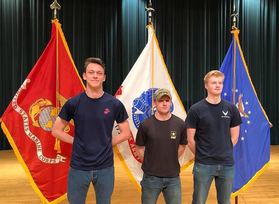 2018 Washougal High School graduate Alec Langen (left) stands with friends Max Churchman (center) and Ryan Bausch in front of flags that represent their chosen military academies in 2018. (Contributed photo courtesy of Max Churchman)