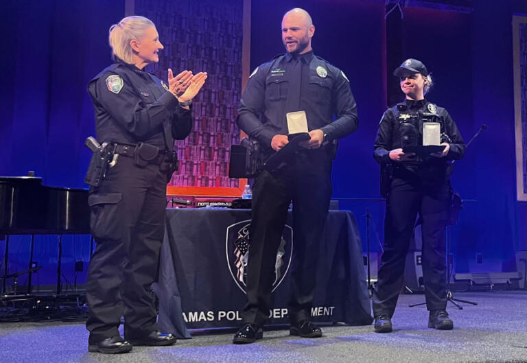 Camas Police Chief Tina Jones (left) presents Medals of Merit to Camas police officers Steven Forgette (center) and Taylor Thune (right) at Grace Foursquare Church in Camas, Thursday, May 23, 2024.