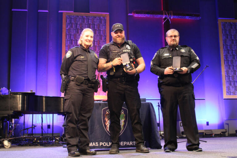 Camas Police Chief Tina Jones (left) Medals of Merit to Camas police officer Ward Kruse (center) and Washougal police Sgt. Thad Eakins (right) at Grace Foursquare Church in Camas, Thursday, May 23, 2024.