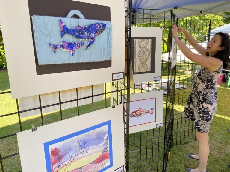 Contributed photo courtesy Rene Carroll 
 Washougal School District art teacher Alice Yang hangs student artwork during the 2023 Parkersville Day event in Washougal.